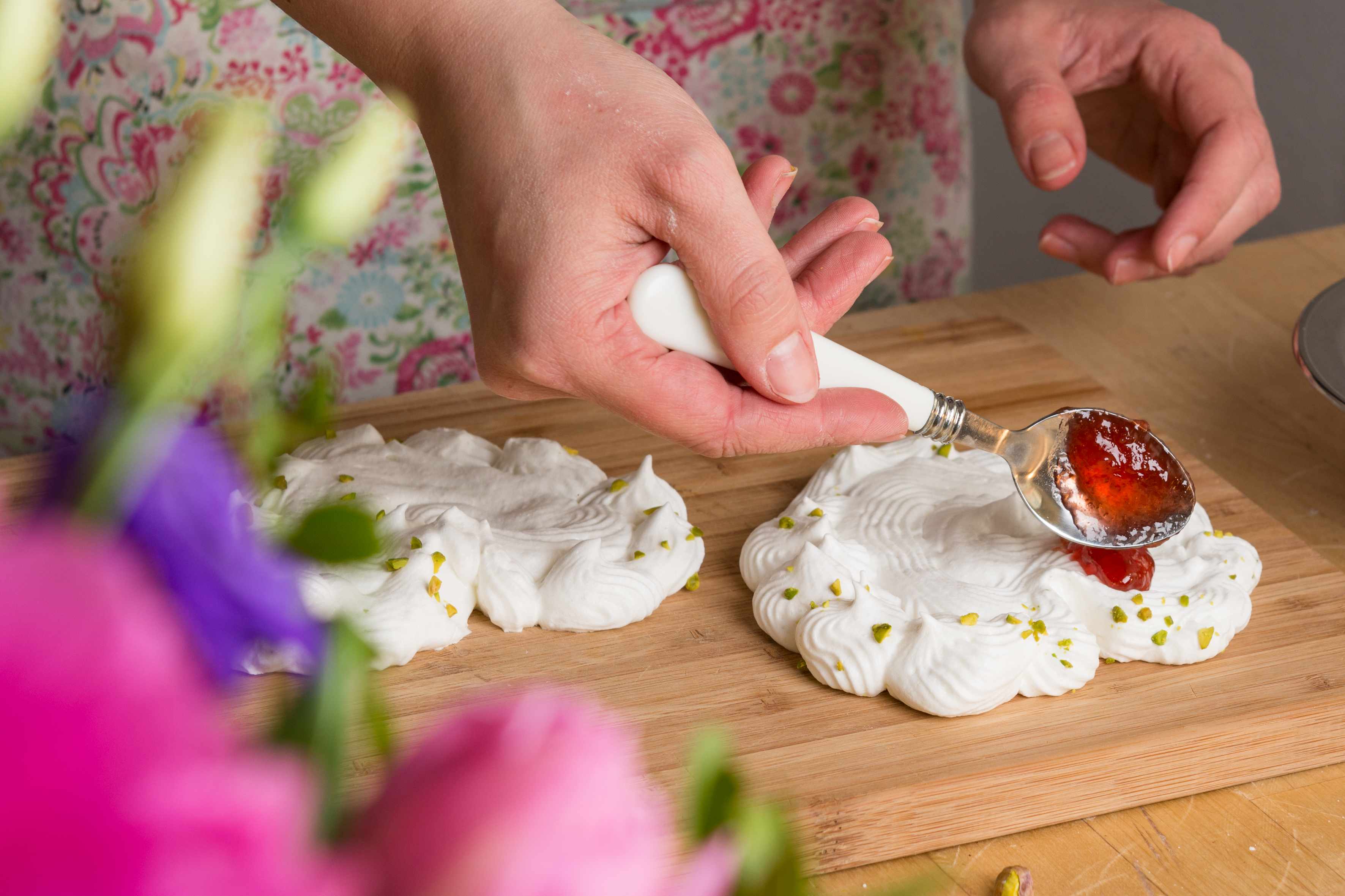 Erdbeermarmelade wird auf den Baiser gestrichen